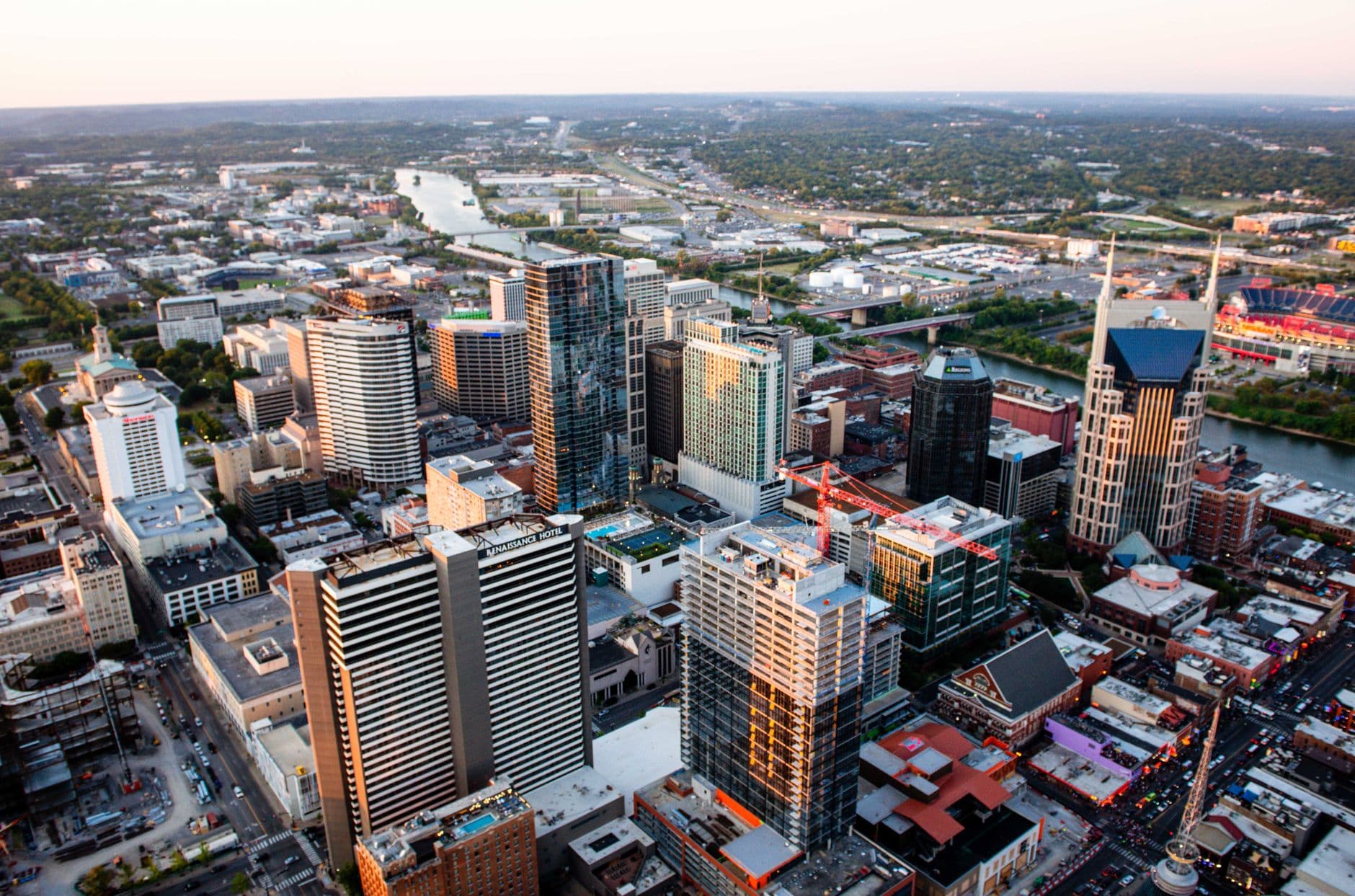 Stunning aerial cityscape of Nashville, Tennessee featuring skyscrapers and urban layout at sunset.
